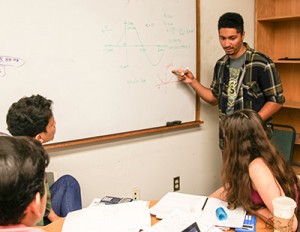 Ian Weaver (at white board) works with ACE students in a physics problem-solving session. Now a senior in astrophysics, Weaver joined the ACE Program his freshman year and has been on the student staff since he was a sophomore. (Credit: C. Lagattuta)