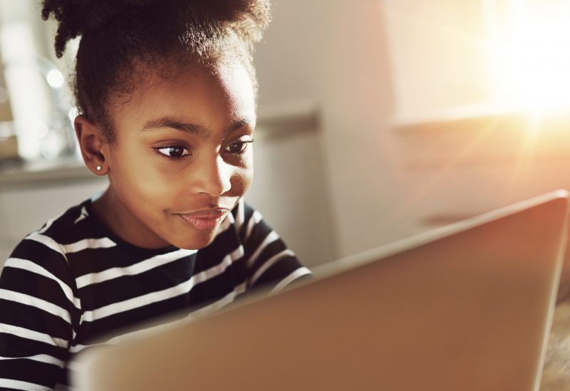 Girls looks attentively at computer screen