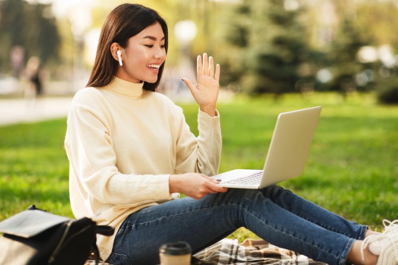 Girl sitting on grass with laptop