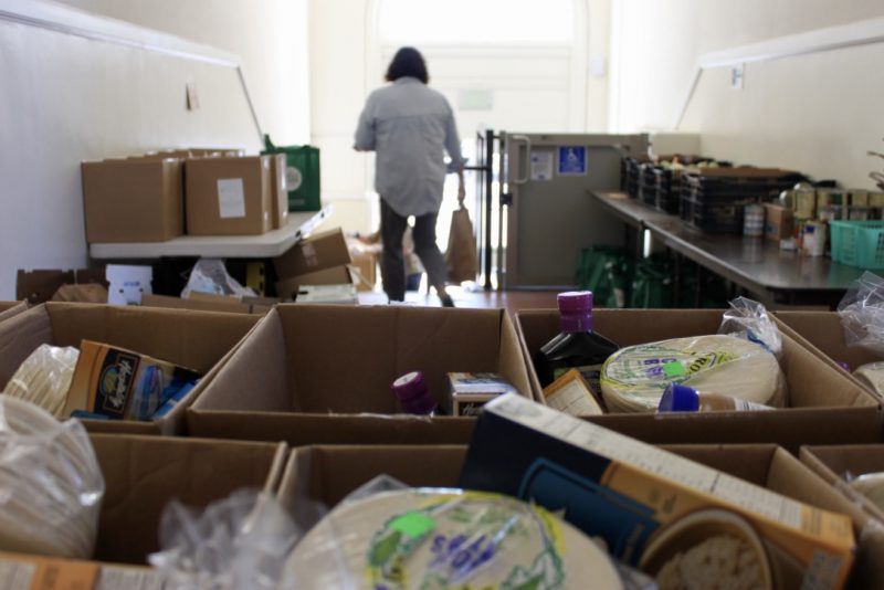 Woman walks out of a room filled with dinated food at Holy Cross church in Santa Cruz County