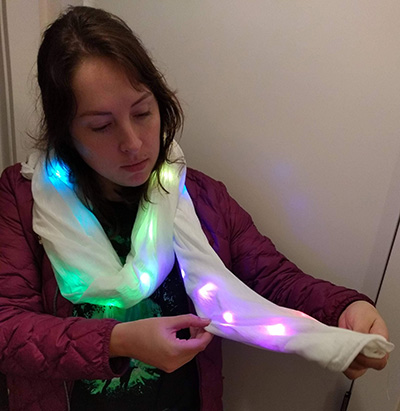 Woman looking at scarf with LED lights